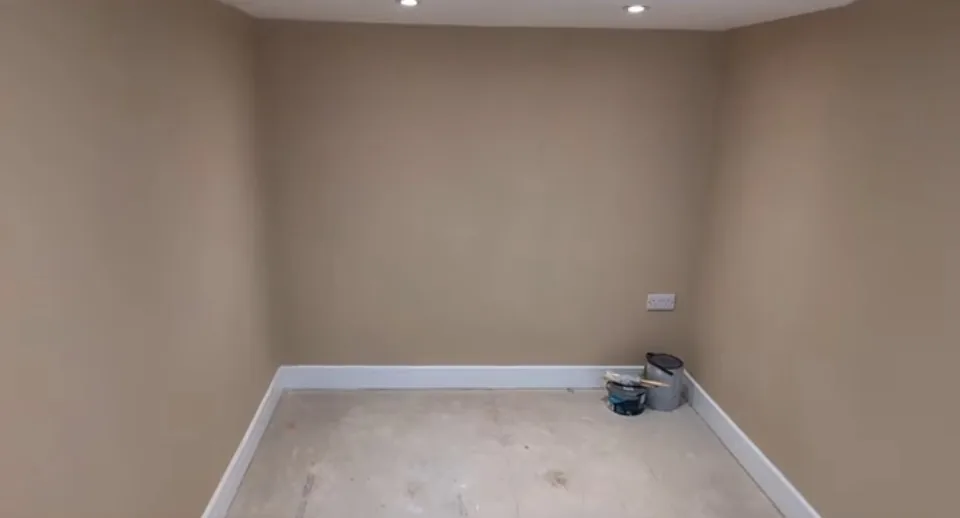 New room with downlights, skirting and decorating materials on the unfinished floor.